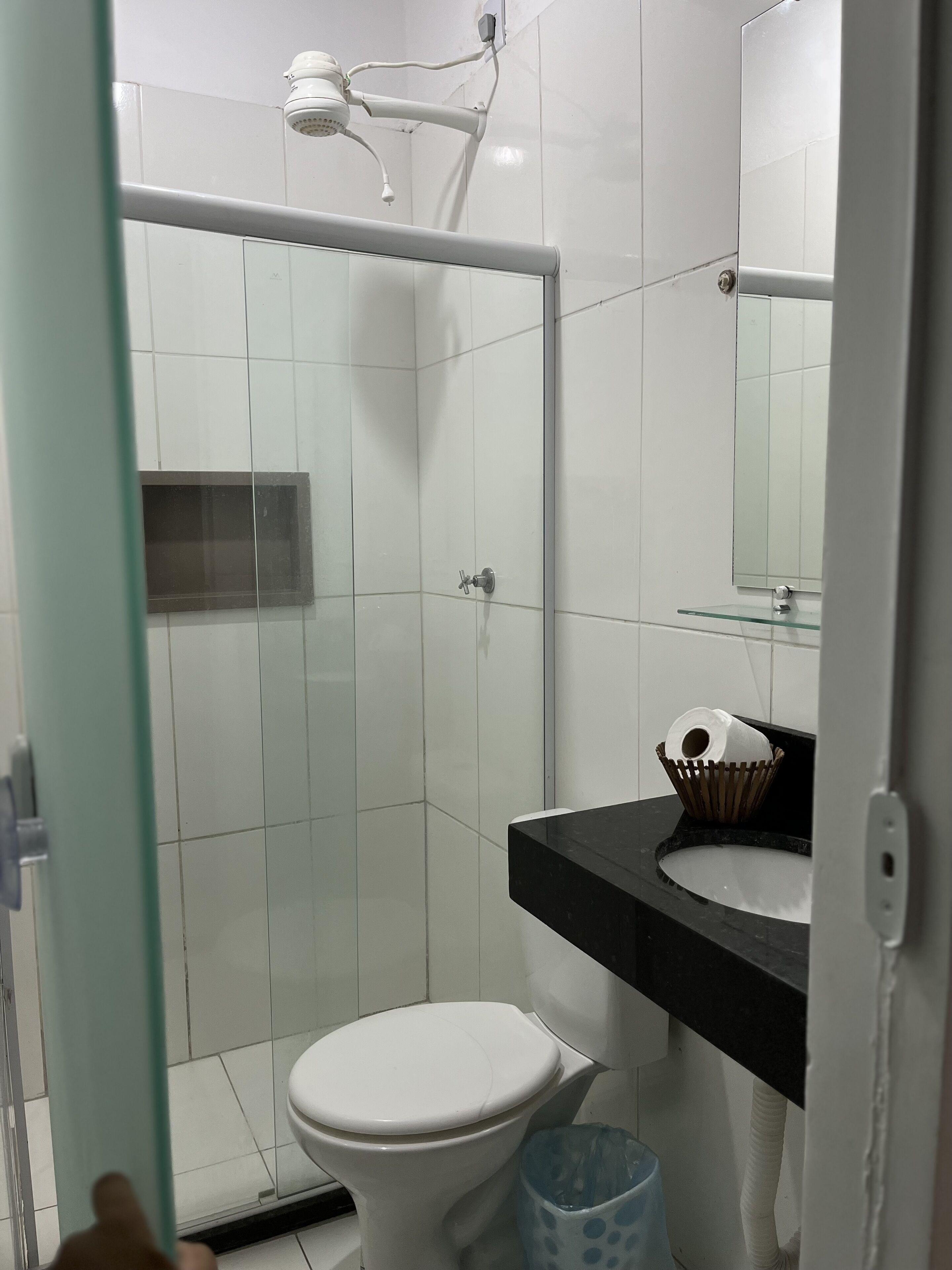 A bathroom with a shower, toilet, and sink.