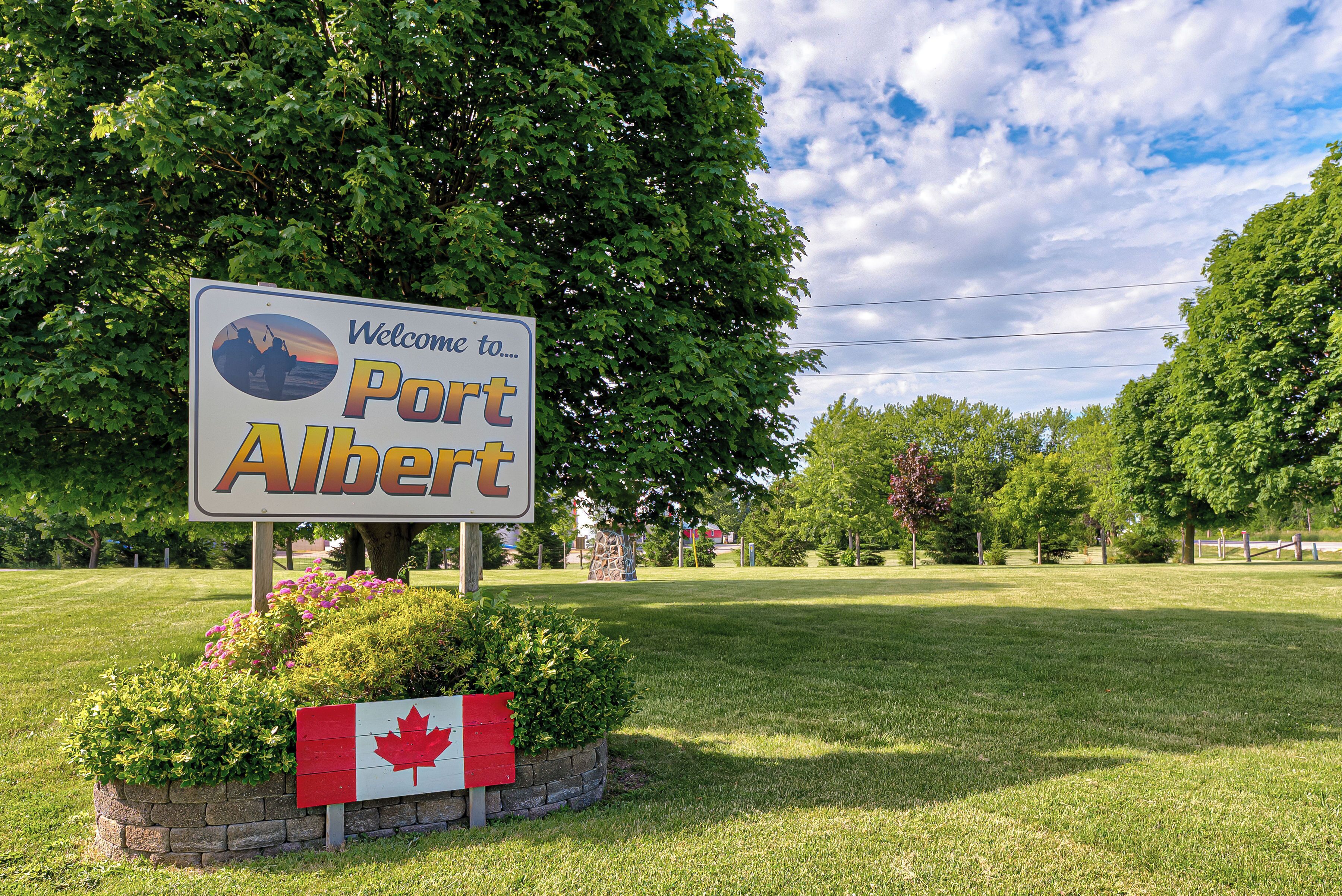 Señal de bienvenida a Port Albert con una bandera canadiense.