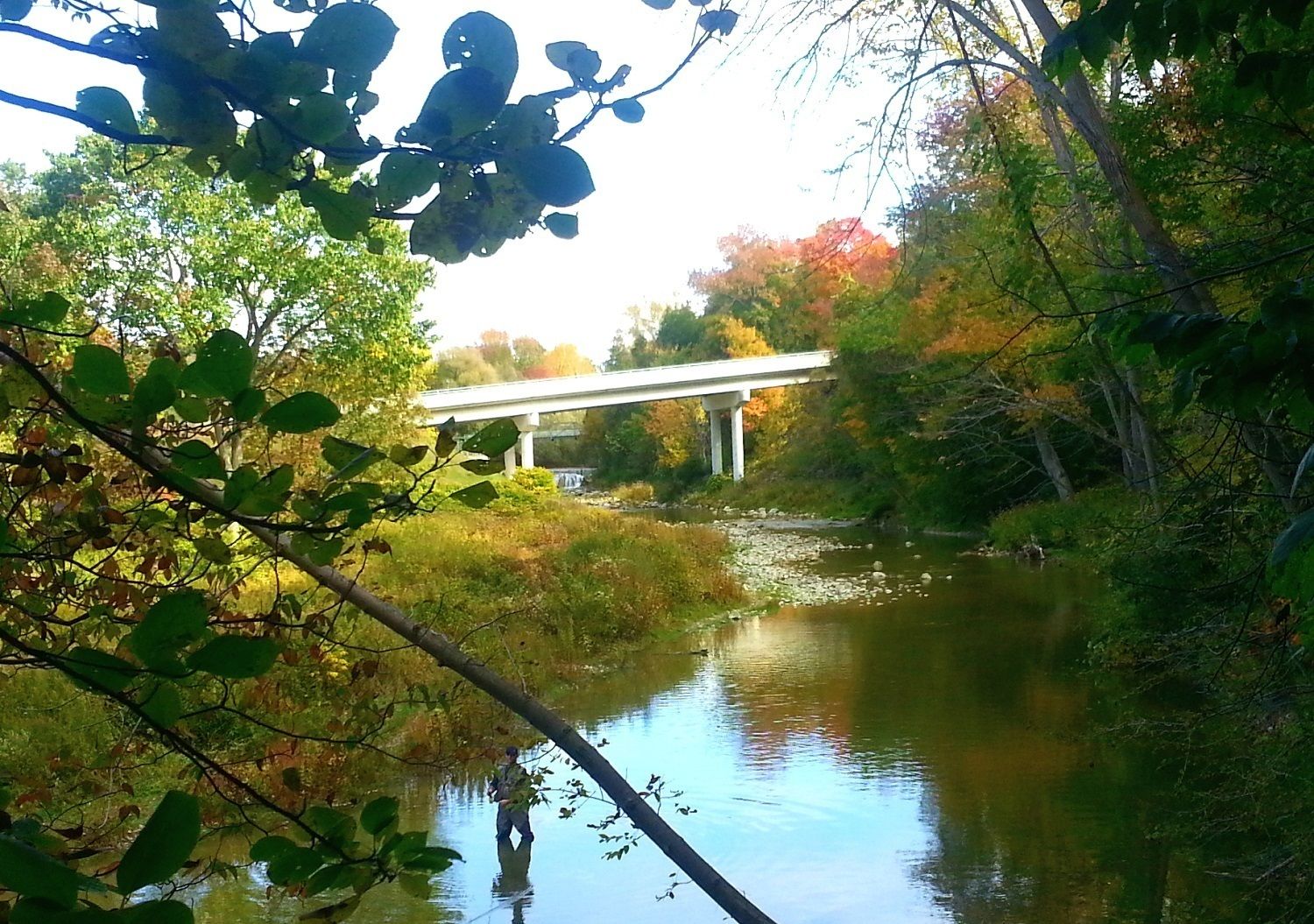 Un río con un puente al fondo.