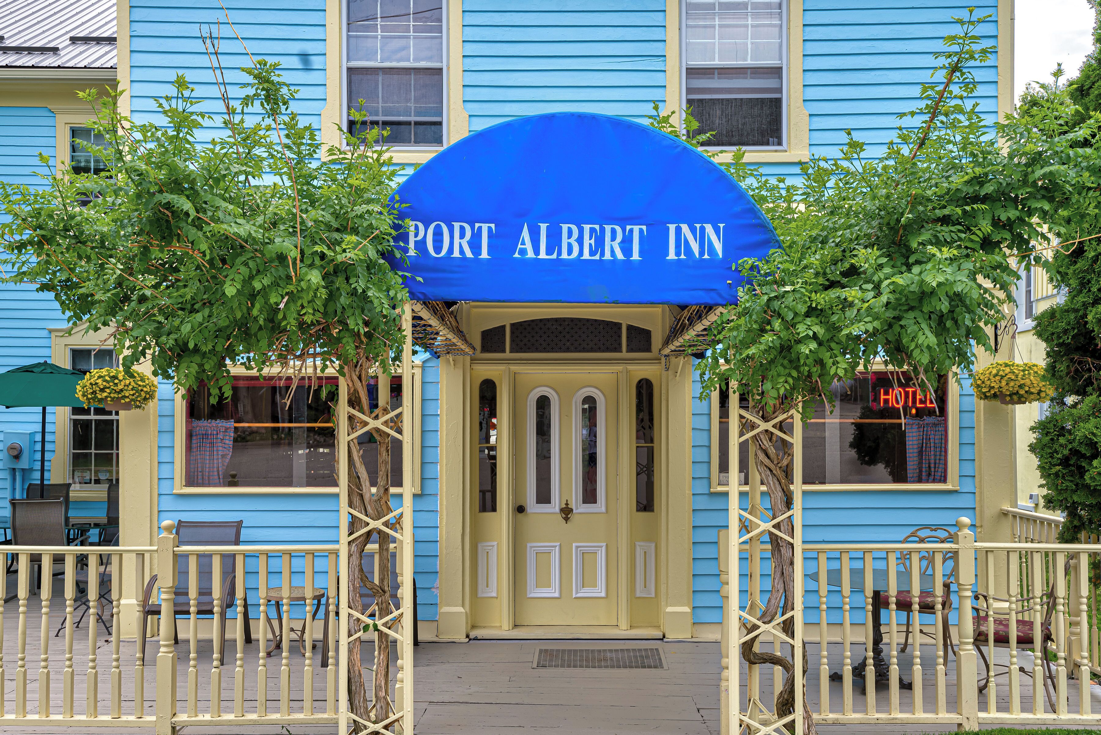 A blue building with a sign reading 'PORT ALBERT INN' and a covered entrance.