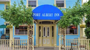 A blue building with a sign reading 'PORT ALBERT INN' and a covered entrance.
