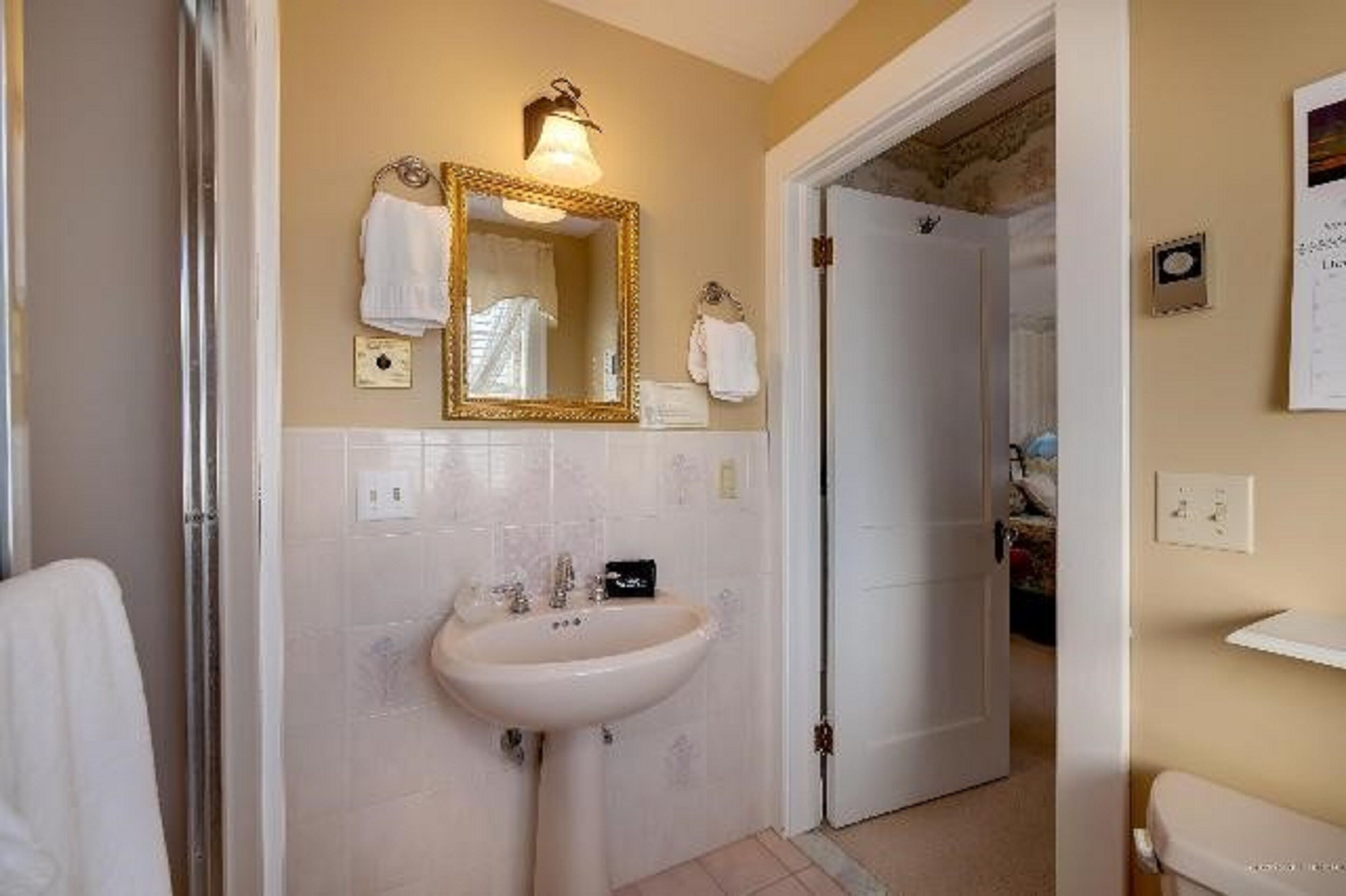 Ein Badezimmer mit Waschbecken, Spiegel und Handtuchhalter.