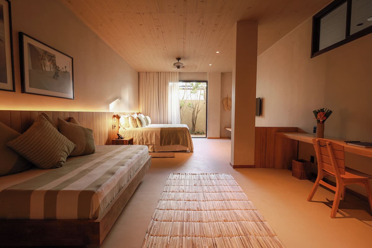Een slaapkamer met twee bedden, een bureau en een stoel.