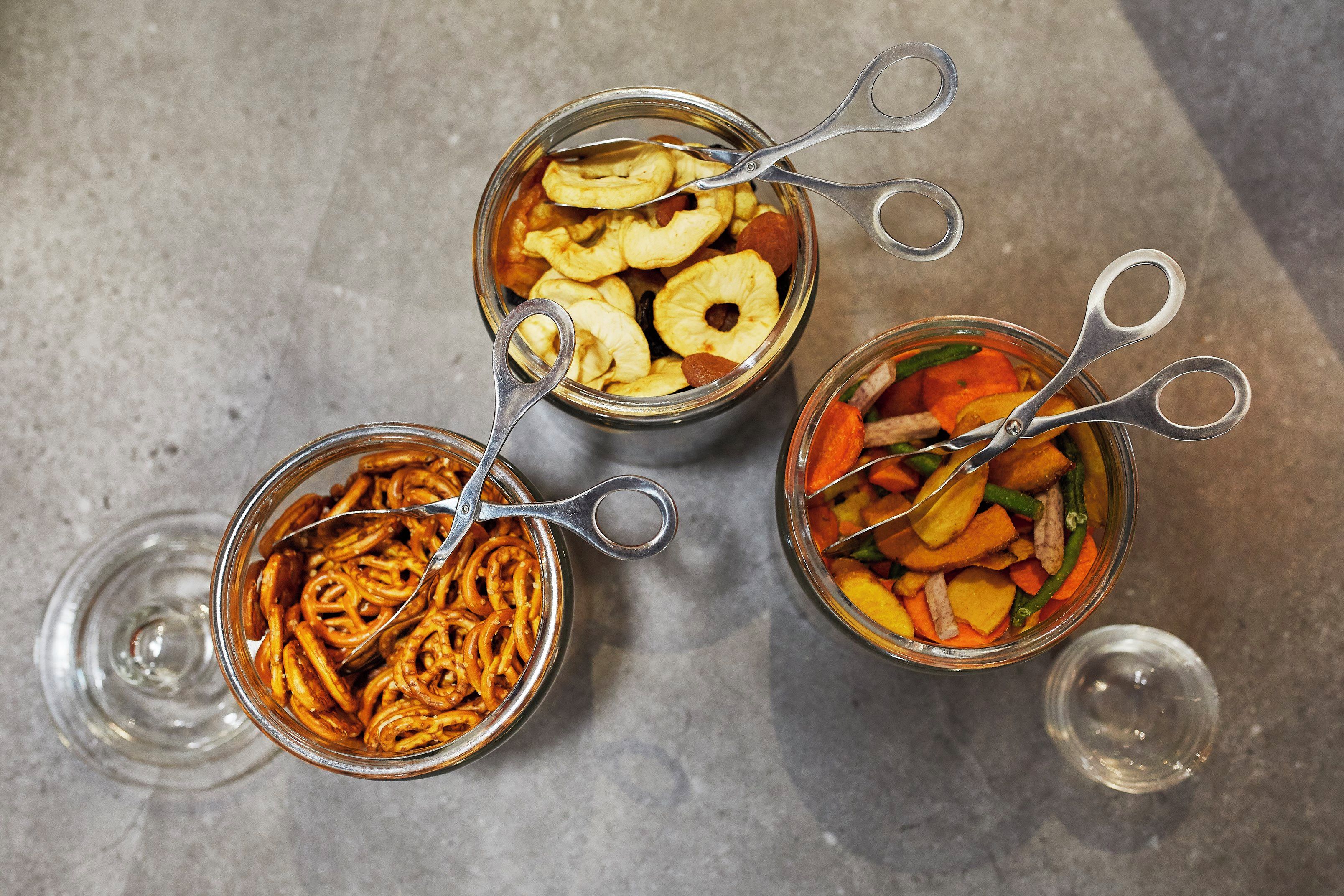 Tres frascos de vidrio con pinzas metálicas, que contienen distintos alimentos.