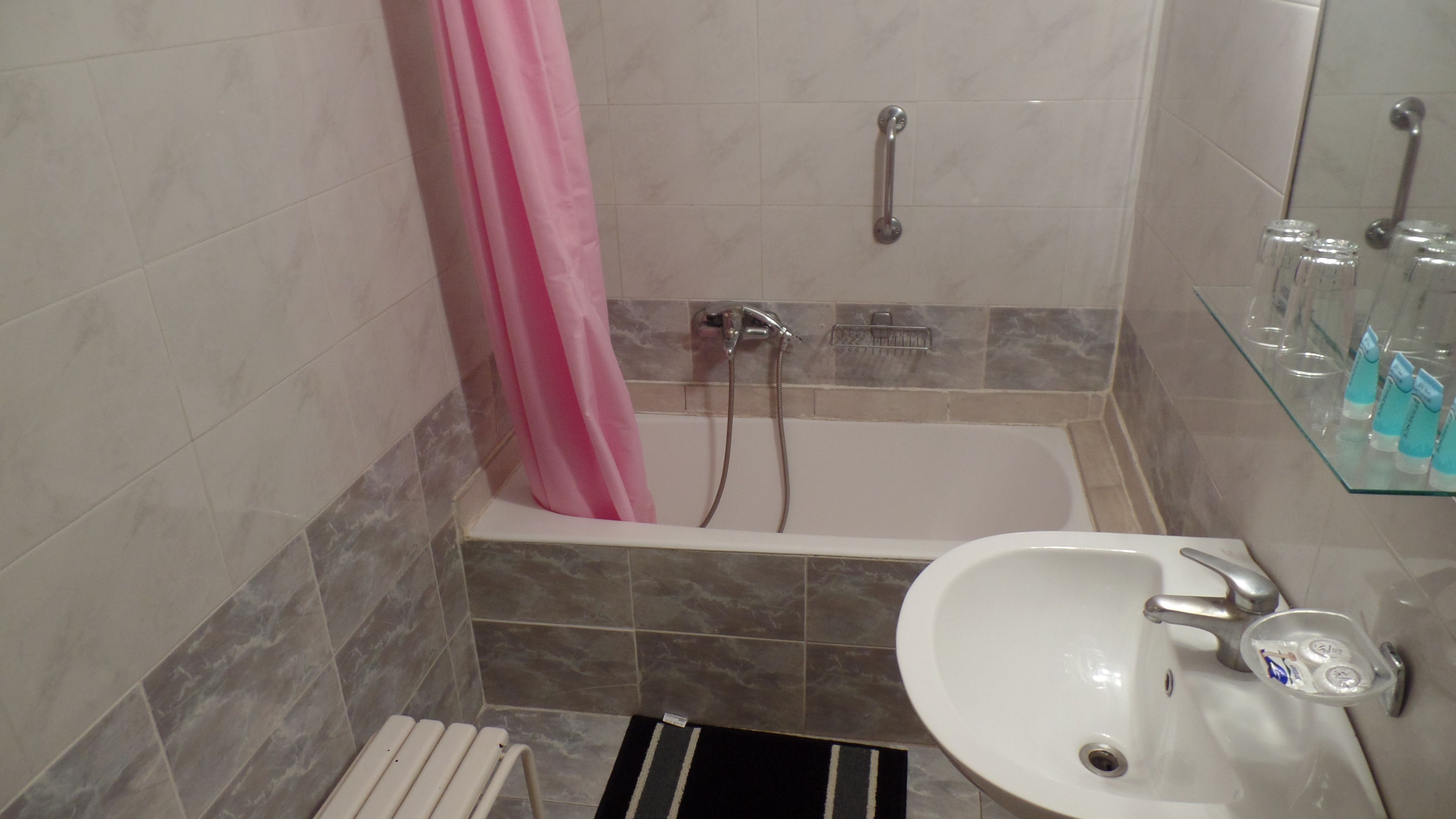Un bagno con vasca, lavabo e box doccia in vetro.