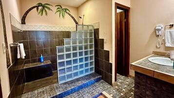 Suite | Badkamer | Een douche, een haardroger, handdoeken, zeep