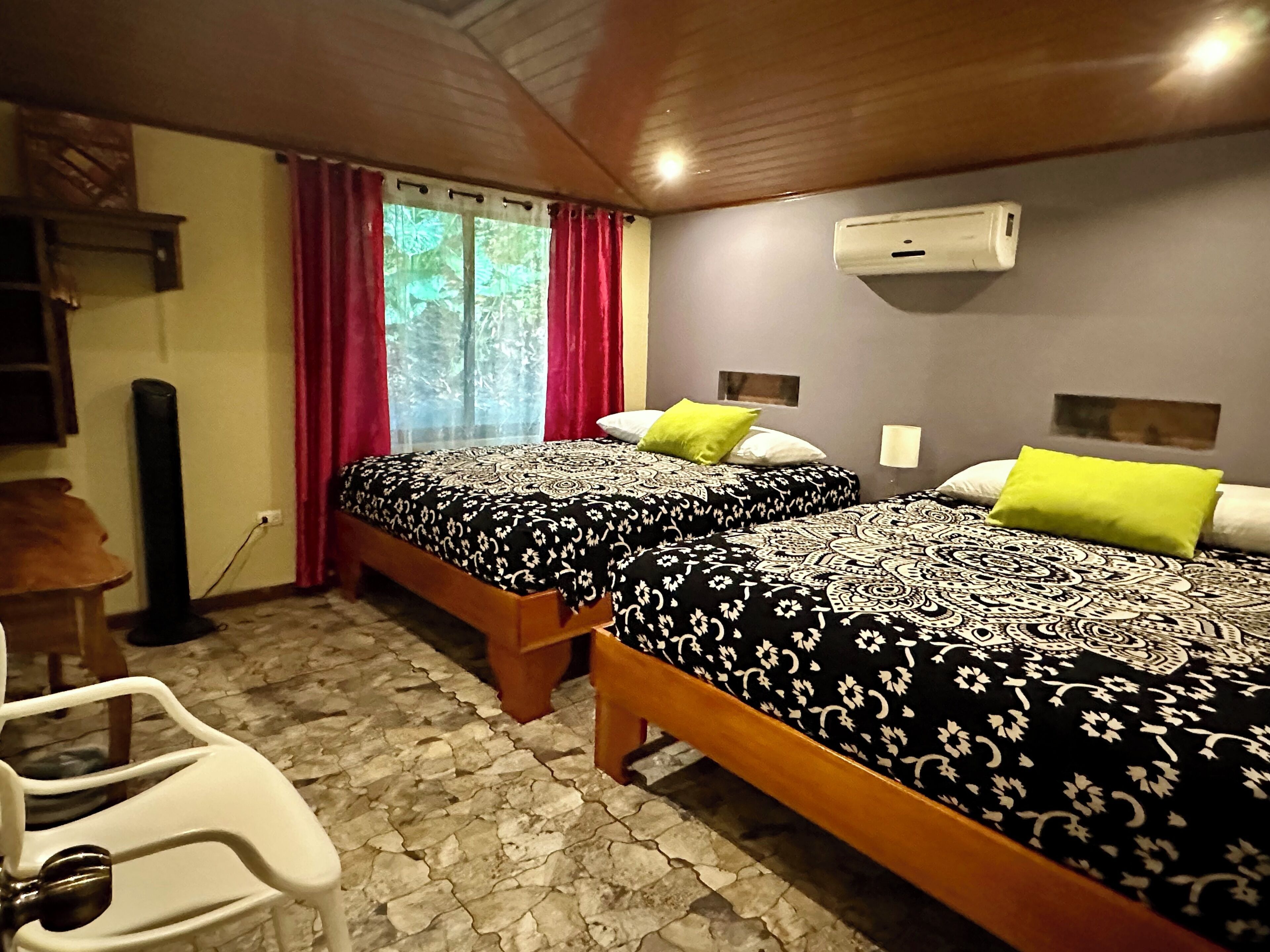 A room with two beds, a desk, and a chair.