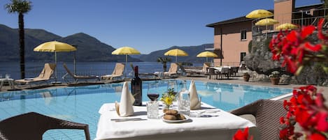 Una piscina al aire libre de temporada, sillones reclinables de piscina