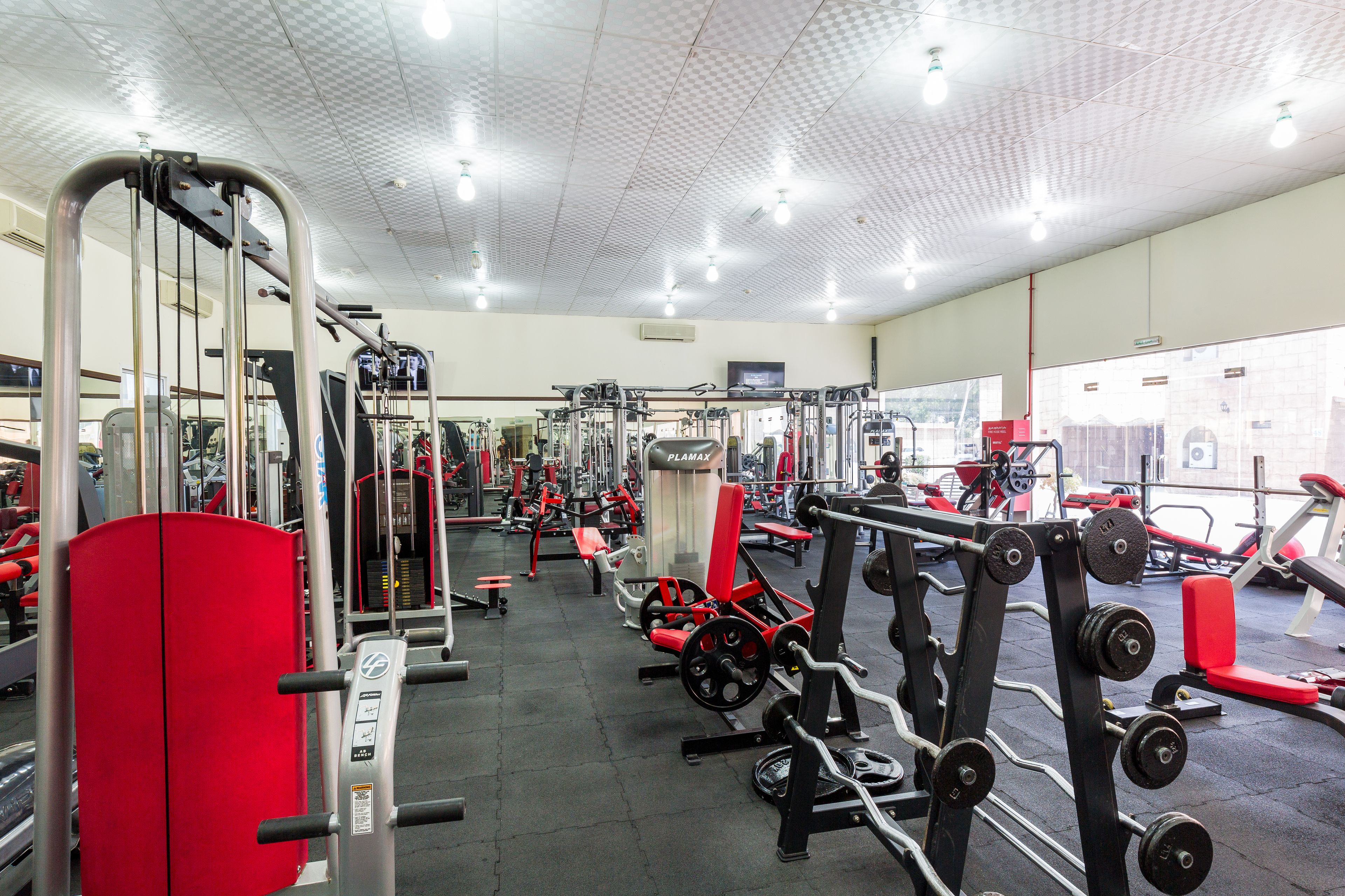 A gym with various exercise equipment, including weight machines and benches.