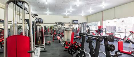 A gym with various exercise equipment, including weight machines and benches.