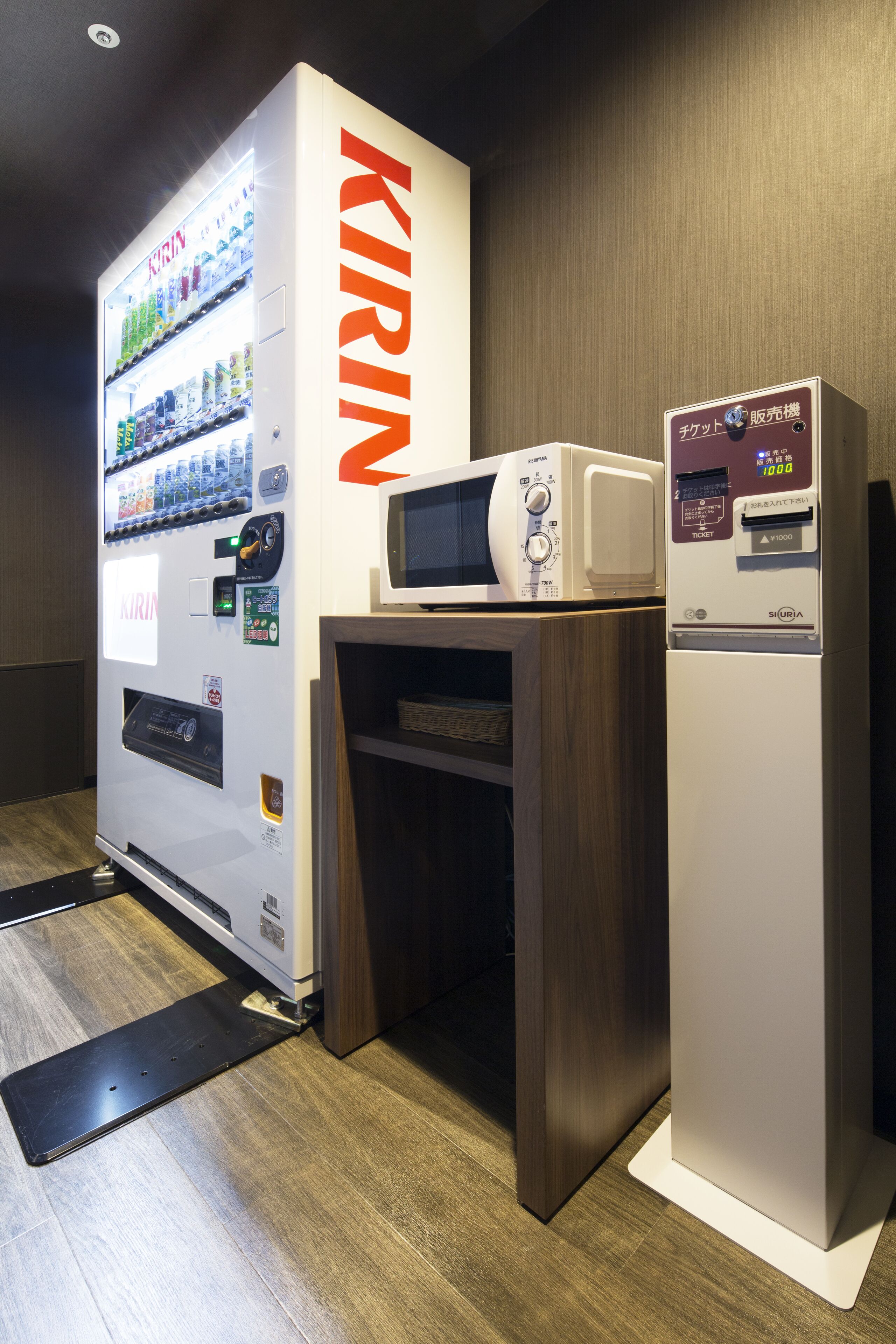 Un distributeur automatique marqué du nom « KIRIN », équipé d’un four à micro-ondes et d’un réfrigérateur.