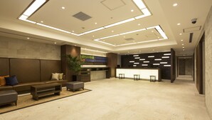 A spacious lobby with a reception desk, seating area, and a large plant. - Hotel MyStays Gotanda Station (Tokyo)