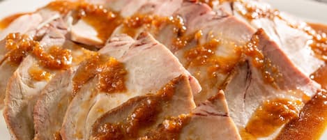 A plate of sliced meat with a glaze.