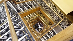 Eine Wendeltreppe mit einem geometrischen Fußbodenmuster und einer zentralen Sitzgelegenheit.