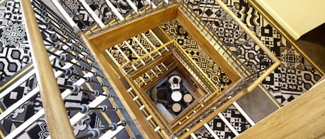 A spiral staircase with a geometric patterned floor and a central seating area.