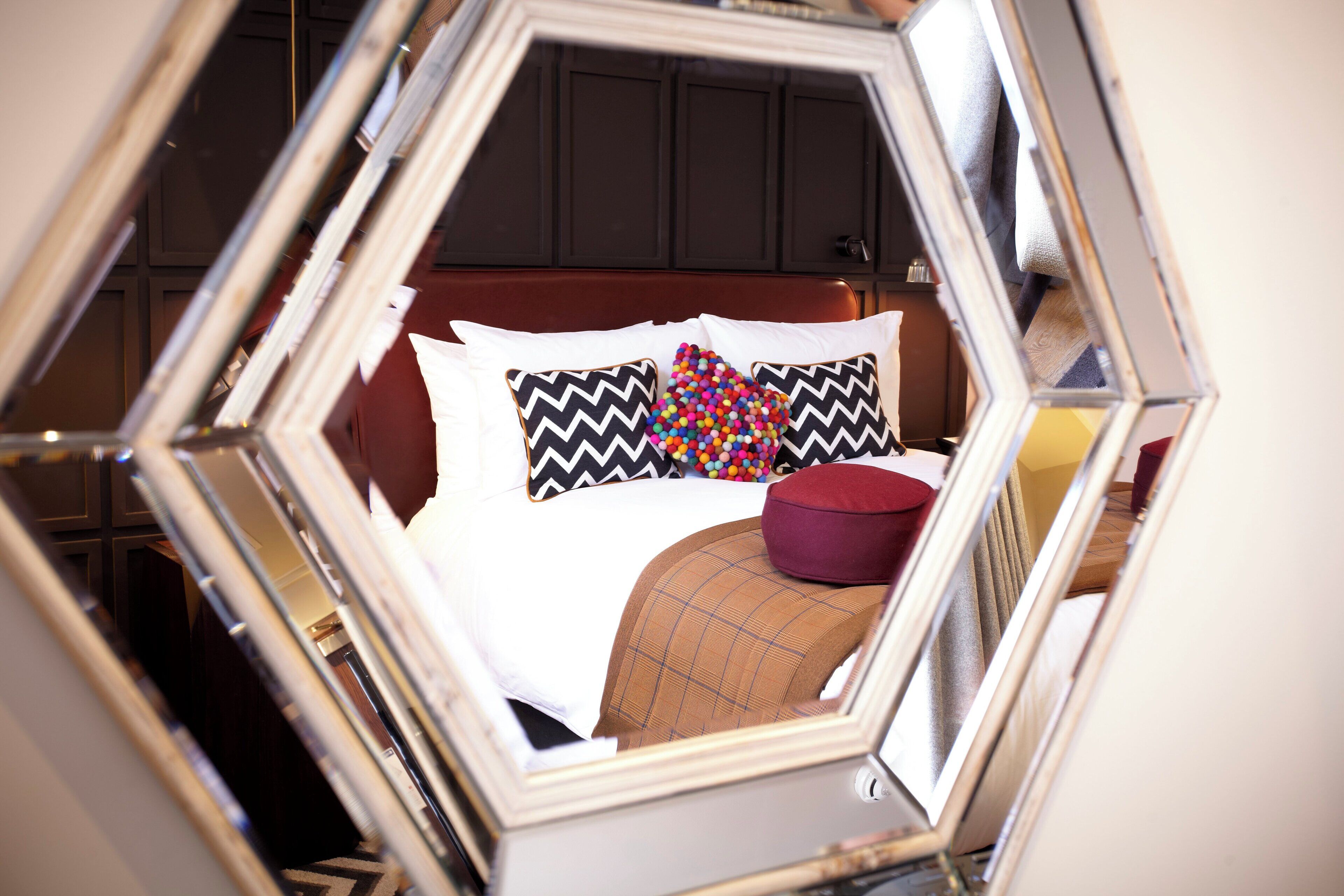 Quarto com cama, almofadas e um travesseiro vermelho.