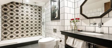 Un baño moderno con ducha, inodoro y tocador.