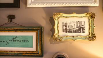 A wall with multiple framed items, including a framed text and a framed photograph.