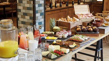 A buffet table with various food items, drinks, and condiments.