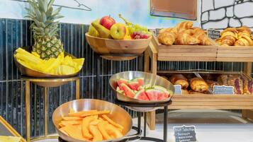 A fruit display with pineapple, apples, grapes, and watermelon.