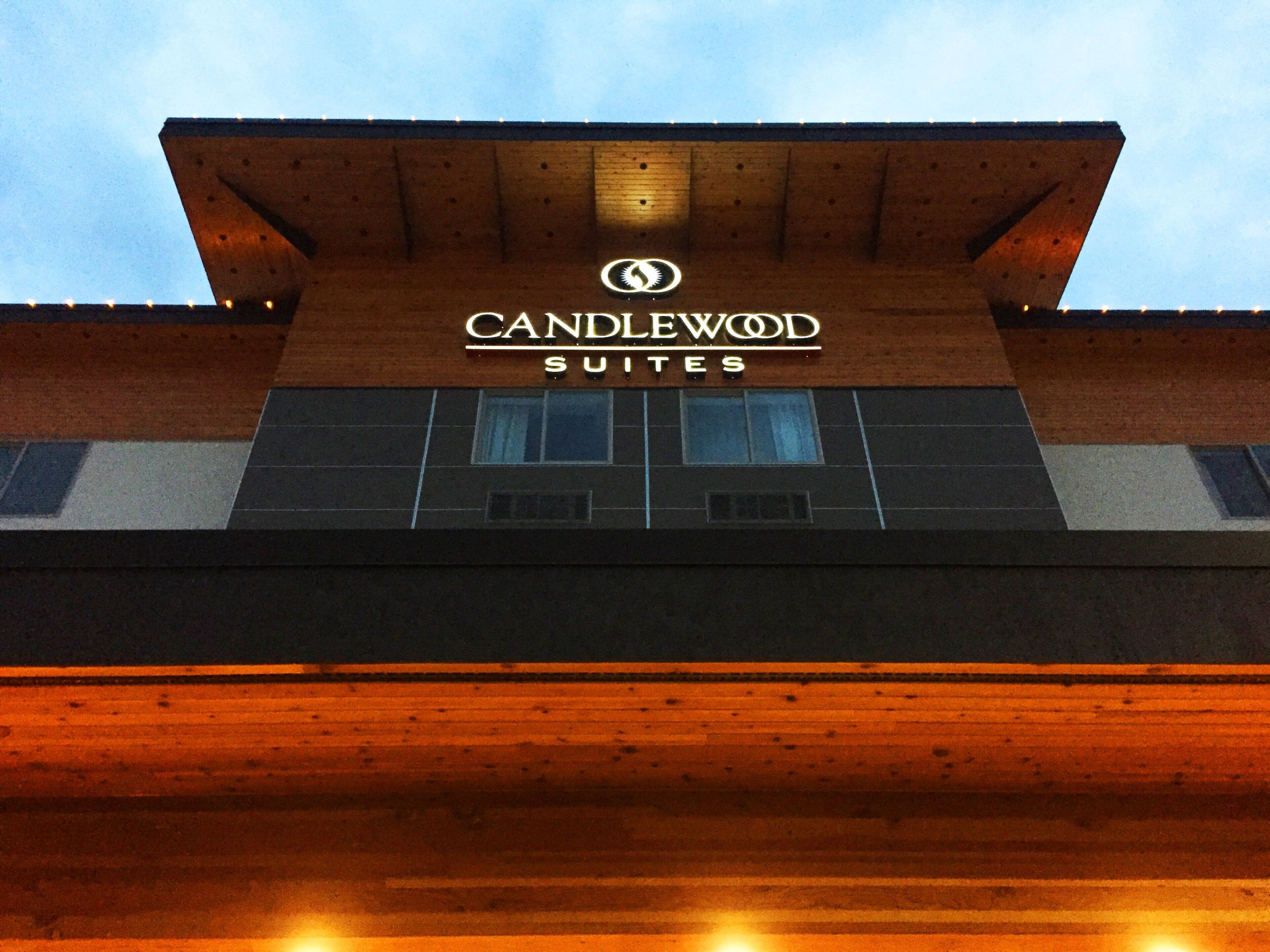 A hotel sign with the name 'CANDLEWOOD SUITES' and a logo above it.