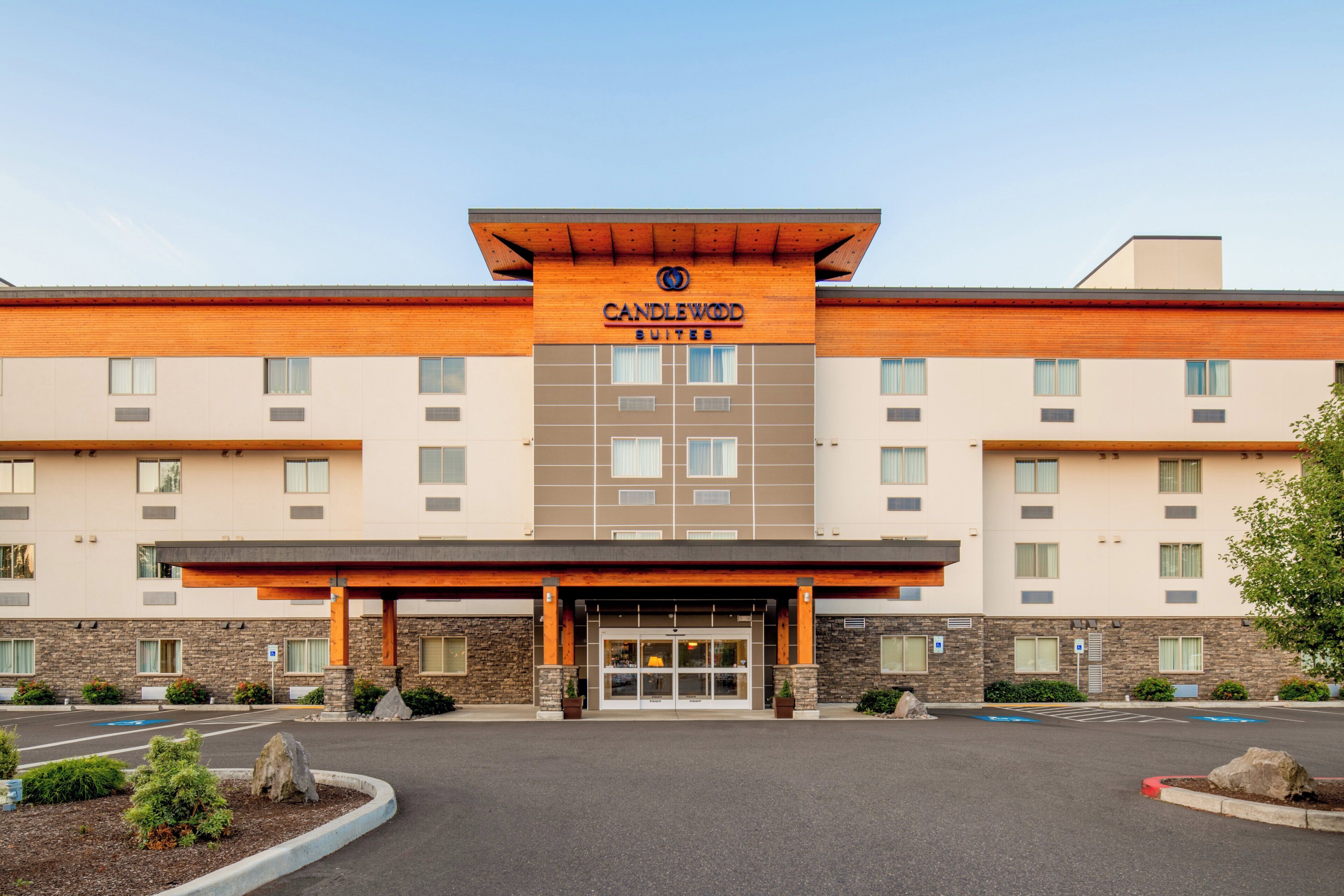 A hotel with a modern design, featuring a prominent 'Candlewood Suites' sign above the entrance.