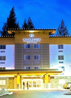 Un hotel con un letrero que dice "CANDLEWOOD SUITES" y una entrada visible con personas afuera.