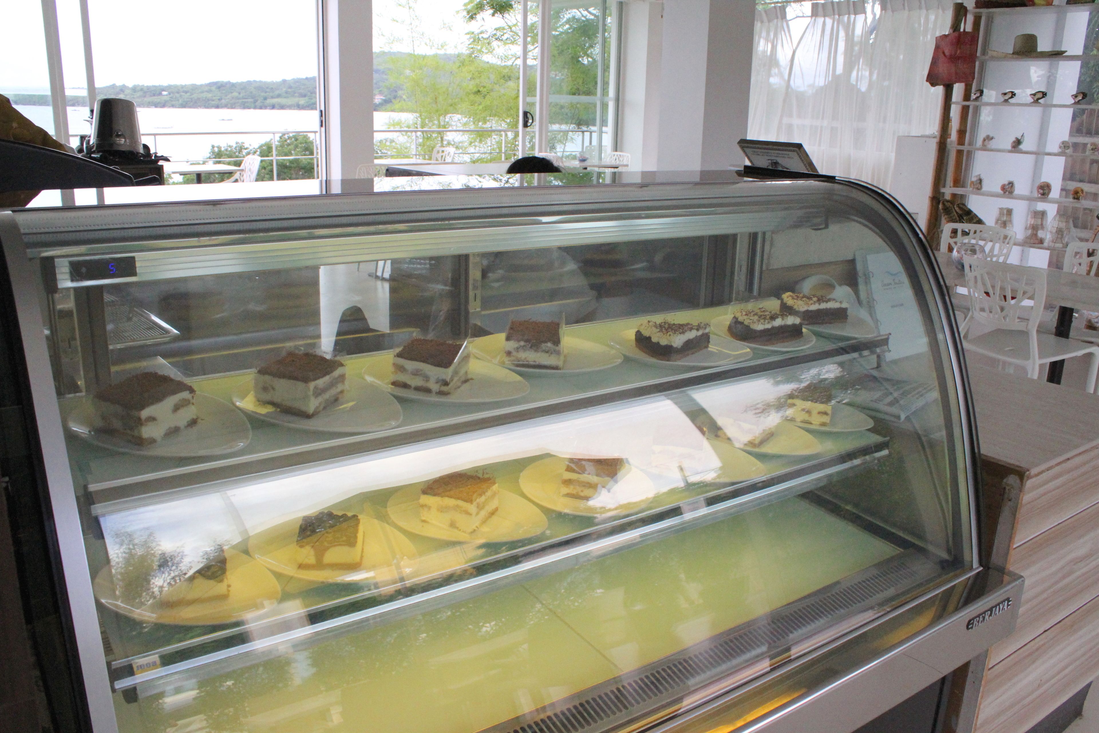 Vitrine de pastelaria com diversos bolos e doces.