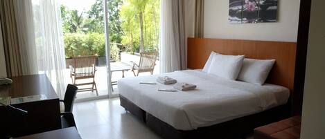 Habitación de hotel con una cama grande, un escritorio y vistas al exterior.
