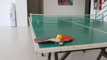 Enjoy a game of table tennis in this room with a table, paddles, and a ball.