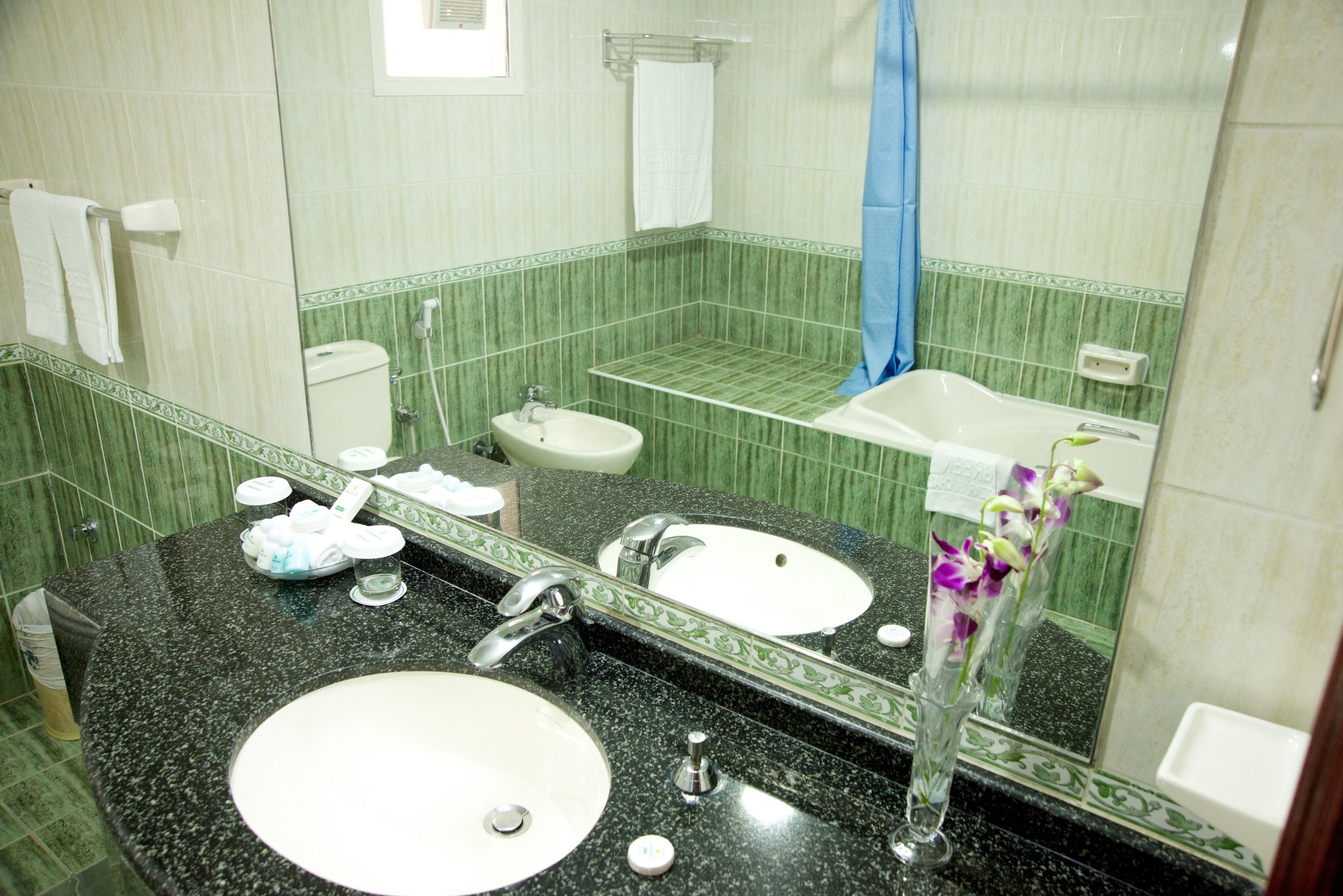 A bathroom with two sinks, a mirror, and a shower.