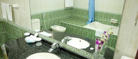 A bathroom with two sinks, a mirror, and a shower.