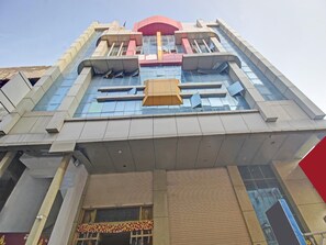 A multi-story building with a prominent central entrance, large windows, and a flat roof.