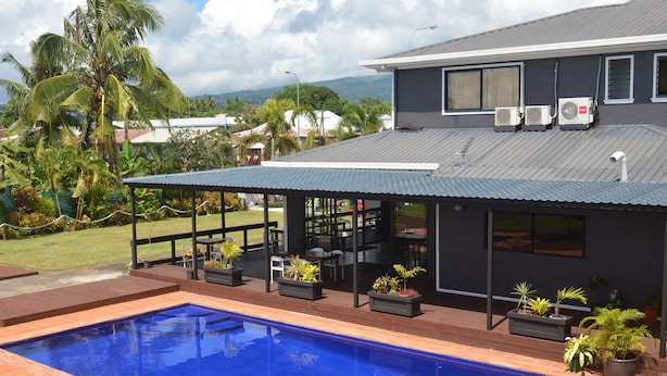 A modern house with a swimming pool, outdoor seating, and air conditioning units. - Travellers Point Hotel (Apia)
