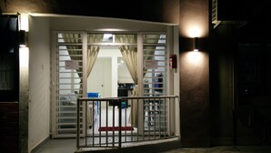 A hotel entrance with a gated door, a visible reception area, and a sign indicating the name "Homestay." - H&A Guest House (Malacca City)