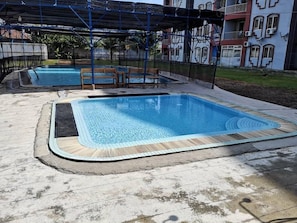 Una piscina con cubierta de madera y zona techada.