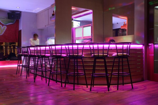 A bar area with a curved counter and multiple stools.