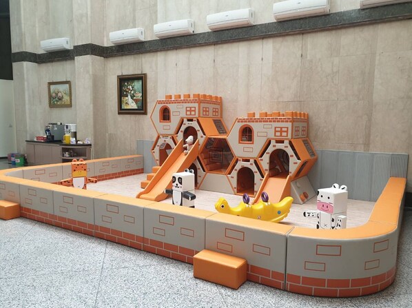 A play area with a slide, a small house, and a yellow toy. - Chuanfu Hotel (Taichung)