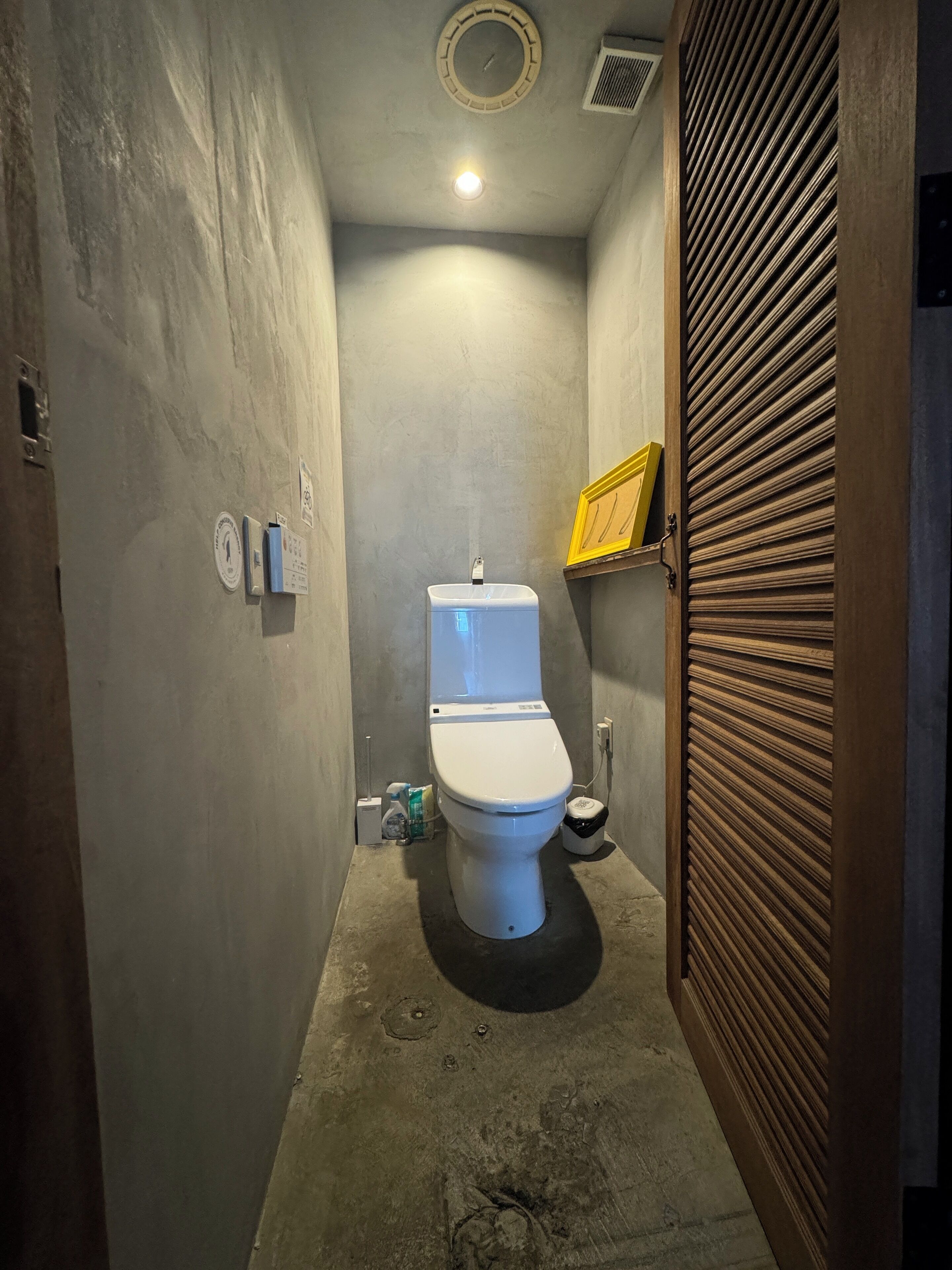 Un bagno piccolo e stretto, con il water, un asciugamani ad aria e un cestino.