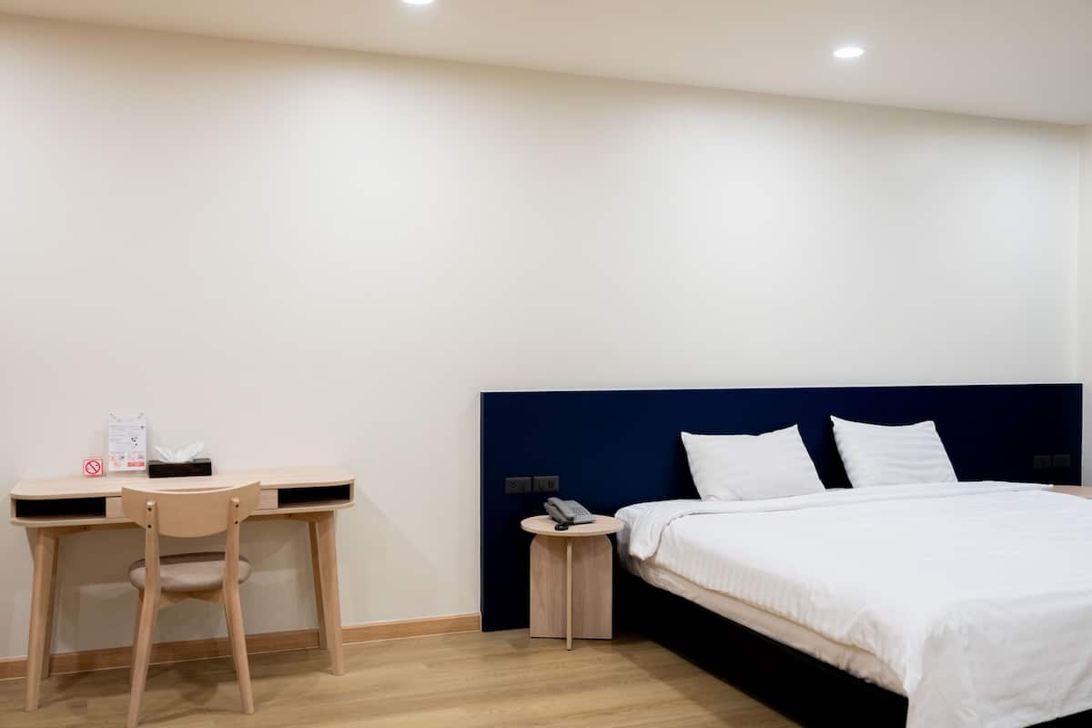 Une chambre d’hôtel avec un lit, un bureau et une chaise.