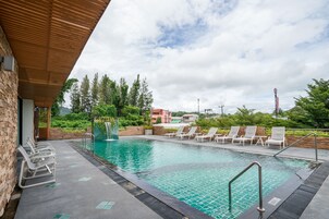 Una piscina al aire libre, sillones reclinables de piscina