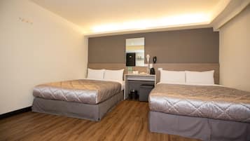Habitación de hotel con dos camas, un escritorio, un espejo y un cesto de basura.