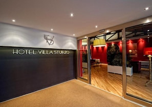 Een moderne hotelentree met een bord waarop 