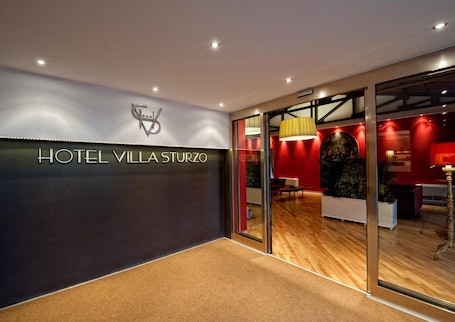 A modern hotel entrance with a sign reading "HOTEL VILLA STURZO".