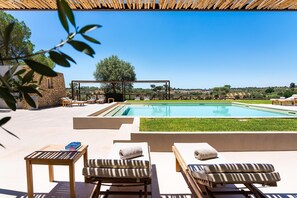 A poolside area with lounge chairs, a table, and a pergola. - Wine Relais Feudi del Pisciotto (Niscemi)