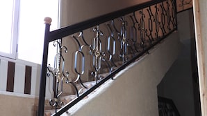 A staircase with a black metal railing and a patterned tile floor. - Auberge La Vallée (Toudgha El Oulia)