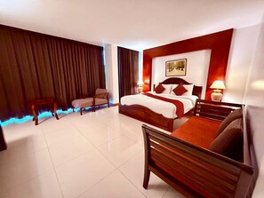 A hotel room with a bed, a chair, a desk, and a lamp. - Sabaidee at Lao Hotel (Vientiane)