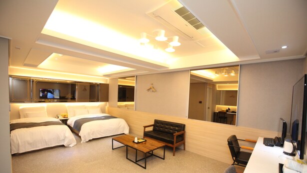A modern hotel room with a bed, a sofa, a desk, and a TV. - 500th Hotel (Mokpo)