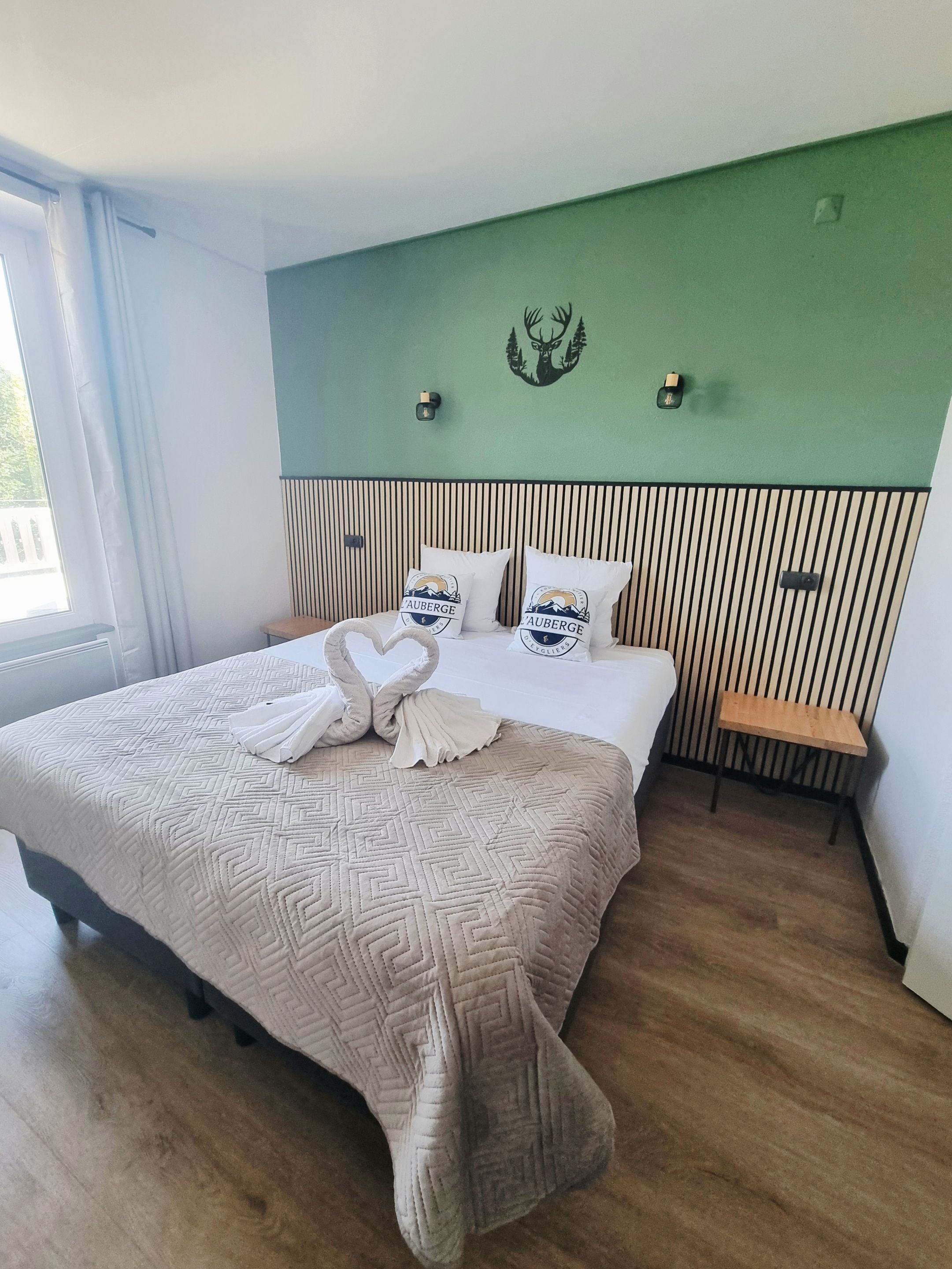 Ein Hotelzimmer mit einem Bett, einer Bank und einer Wandleuchte.