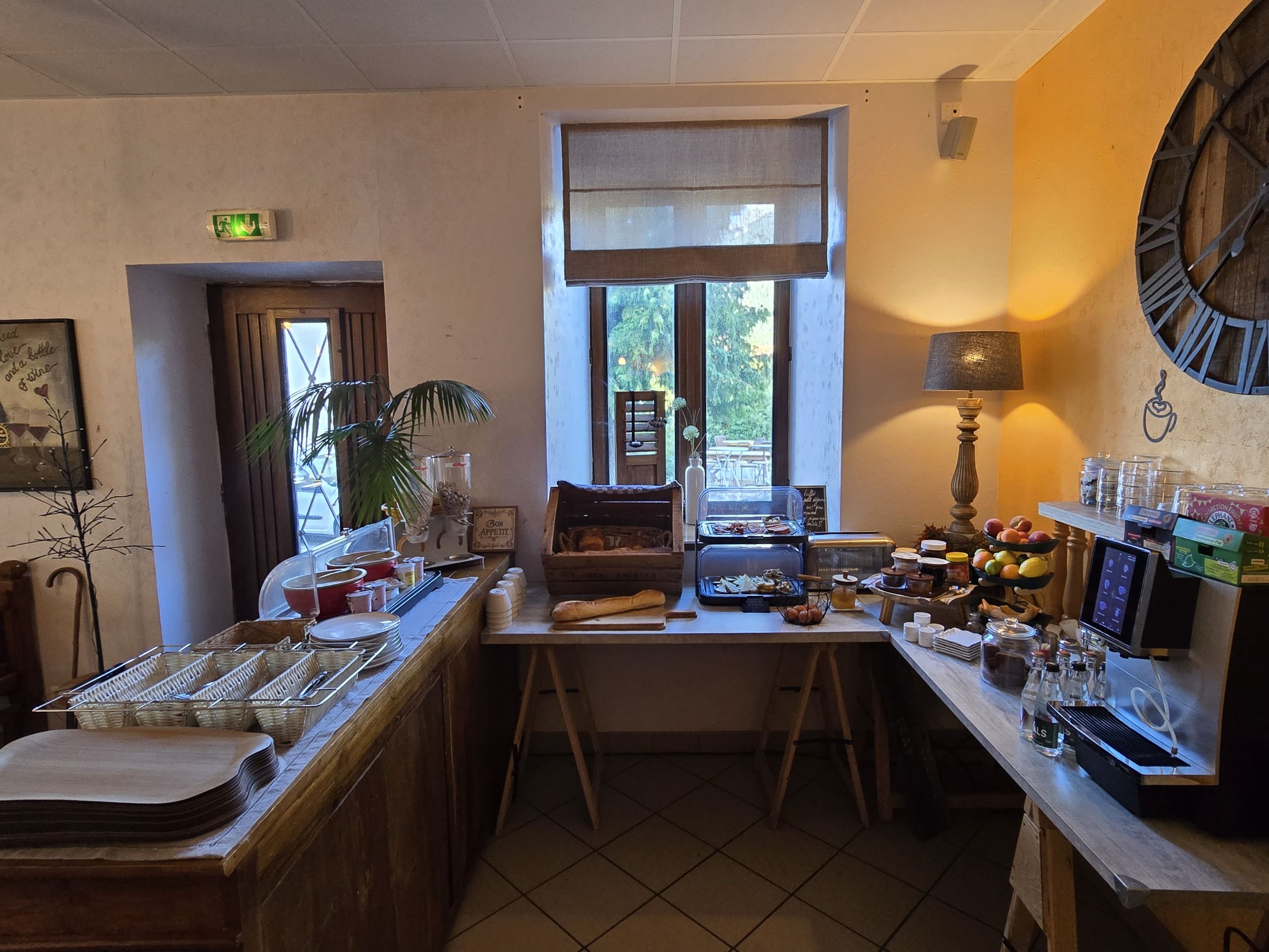 A café with a counter, a window with a view, a clock, and various food items displayed.